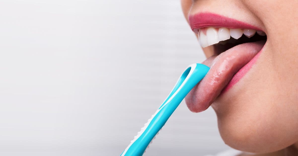 come-pulire-la-lingua Ragazza pulisce la lingua con un raschietto linguale